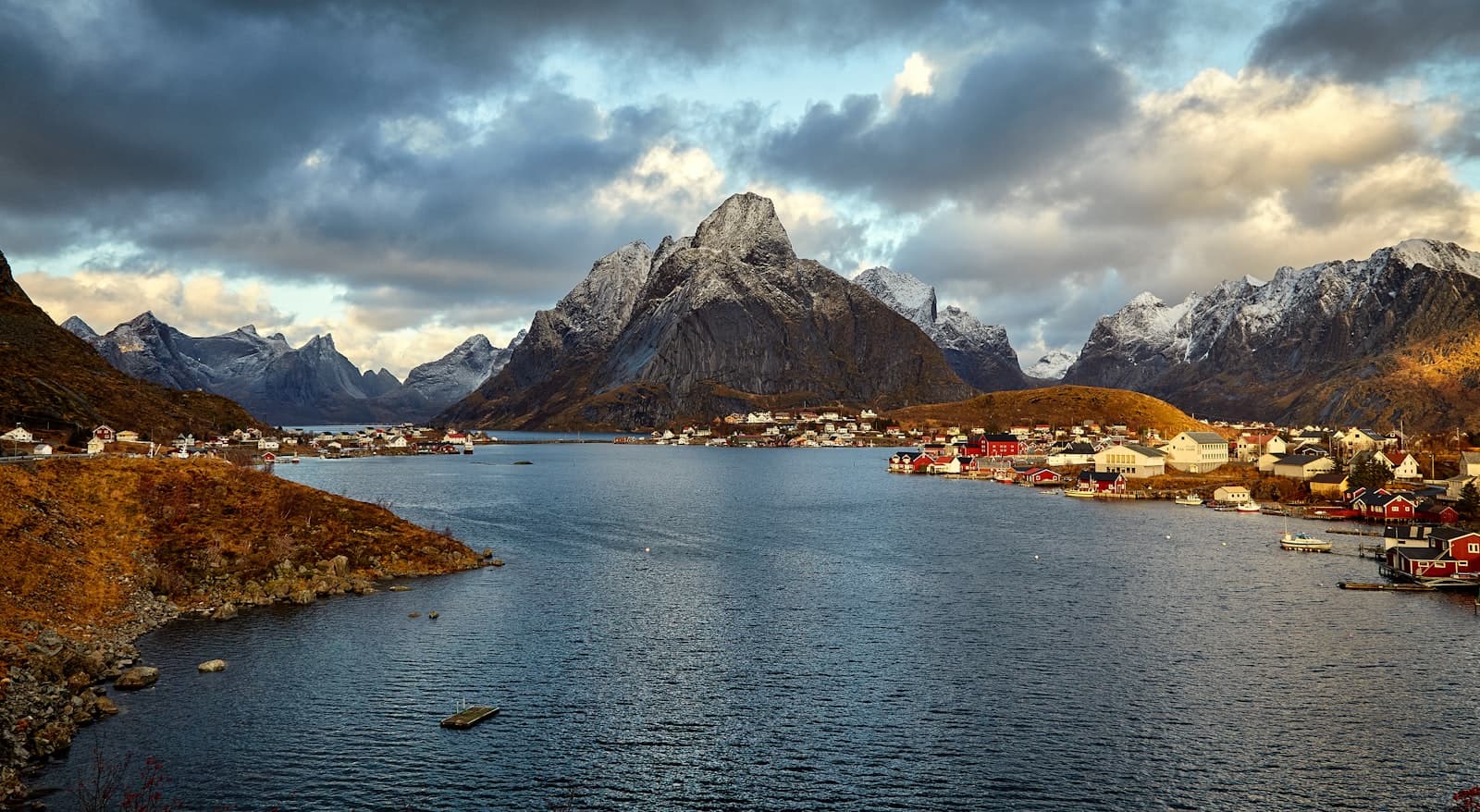 A green, mist-touched fjord under soft light